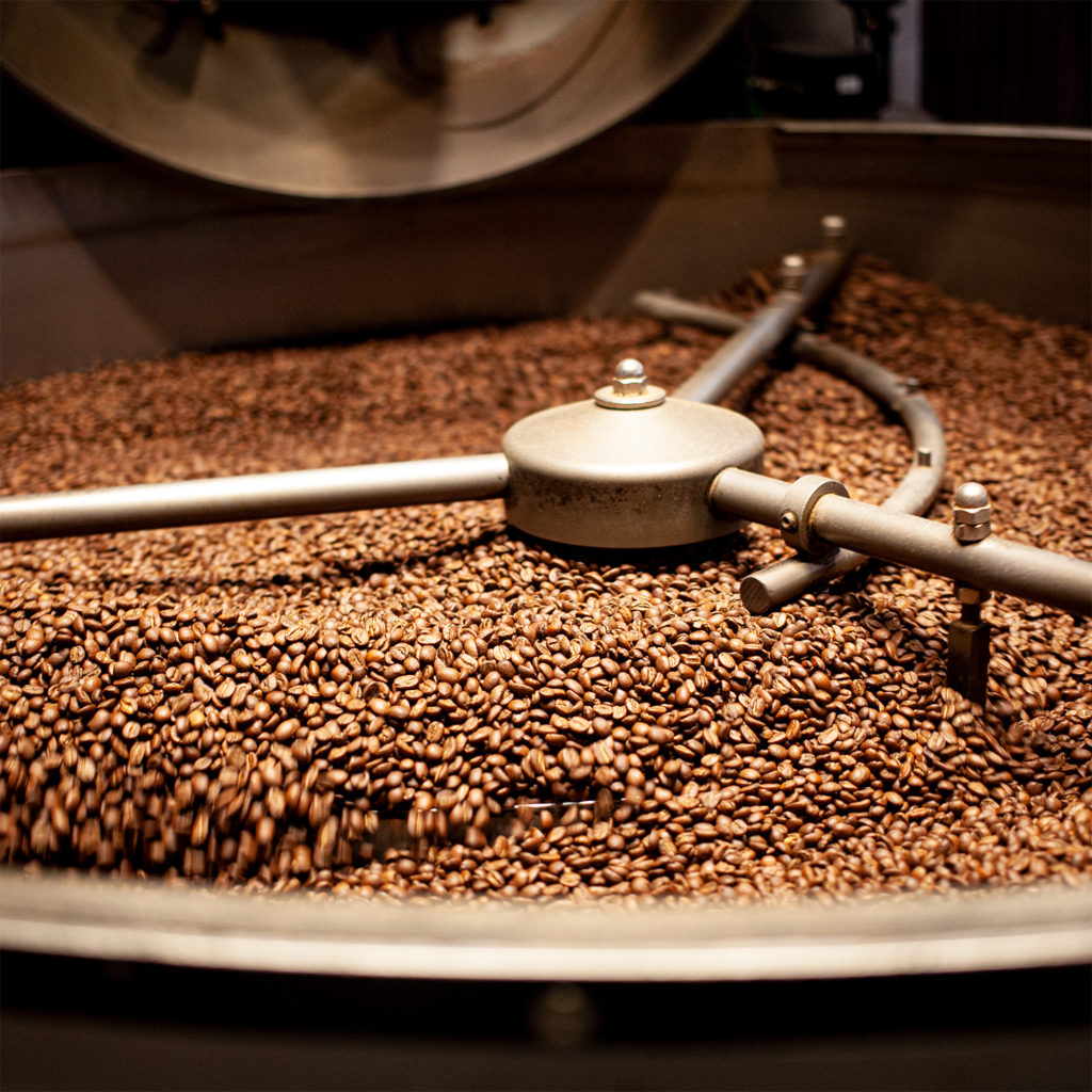 Geröstete Kaffeebohnen liegen im sich drehenden Abkühlsieb unserer Röstanlage.